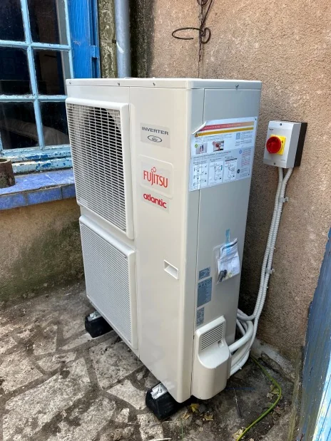 Pompe à chaleur air/eau : Unité extérieure dans une cour.